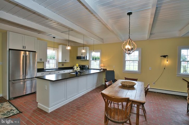 kitchen featuring white cabinets, a baseboard radiator, stainless steel appliances, and a wealth of natural light