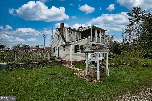 view of home's exterior with a lawn and a sunroom