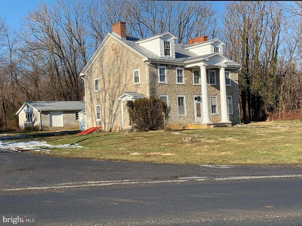 greek revival inspired property featuring a front lawn