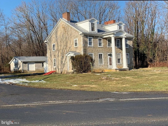 greek revival inspired property featuring a front lawn