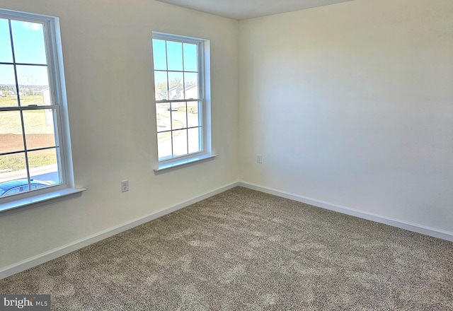 empty room featuring baseboards and carpet flooring