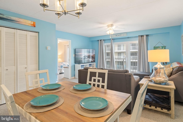 dining area with light colored carpet and ceiling fan with notable chandelier