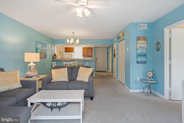 living room with light carpet and ceiling fan with notable chandelier