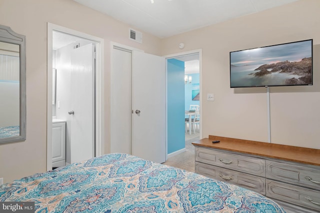 bedroom featuring connected bathroom and light carpet