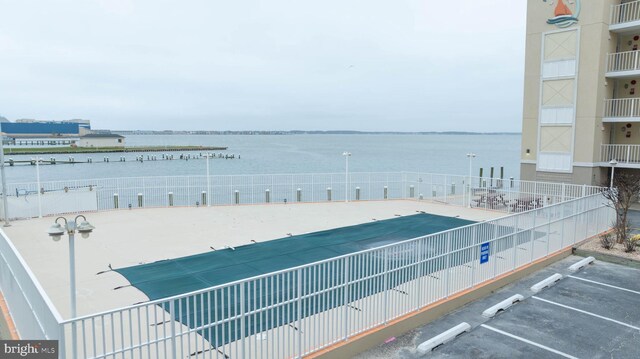 view of patio / terrace featuring a community pool and a water view