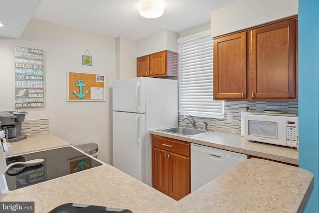 kitchen featuring white appliances, tasteful backsplash, and sink