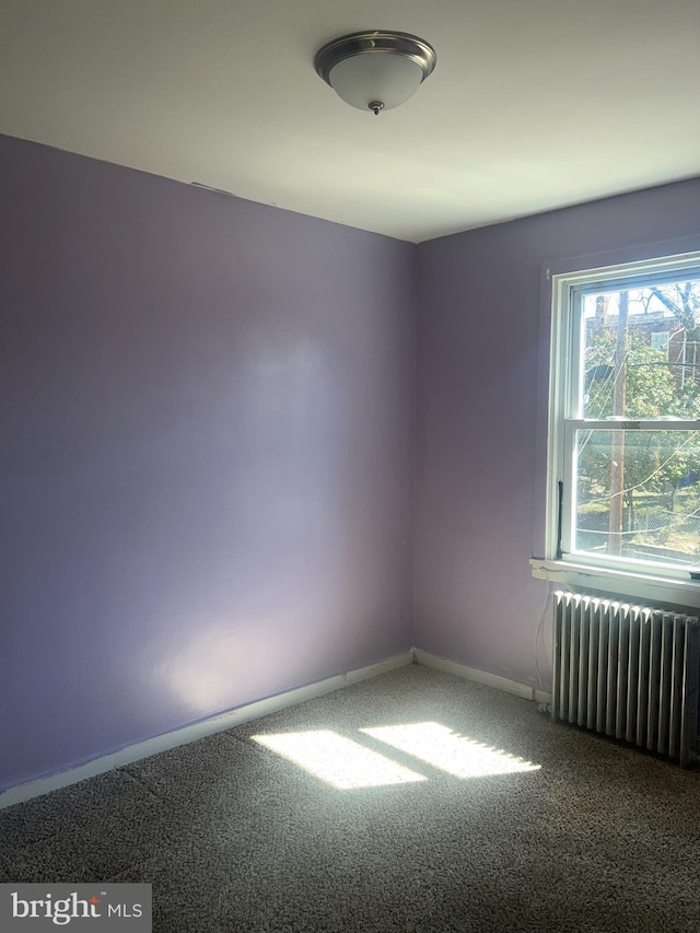 carpeted empty room featuring radiator