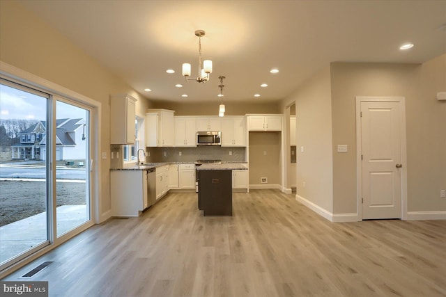 kitchen with stainless steel appliances, tasteful backsplash, visible vents, and a healthy amount of sunlight