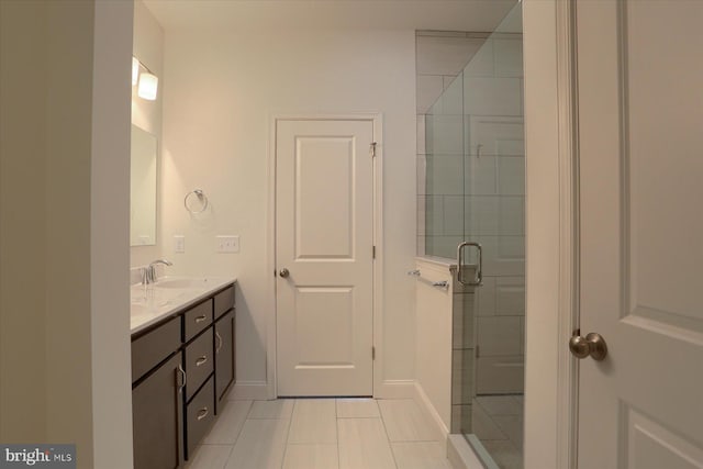 bathroom featuring a stall shower, a sink, baseboards, and double vanity