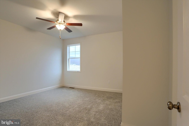 spare room featuring carpet, visible vents, baseboards, and a ceiling fan