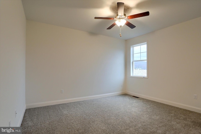 empty room with ceiling fan, carpet floors, visible vents, and baseboards