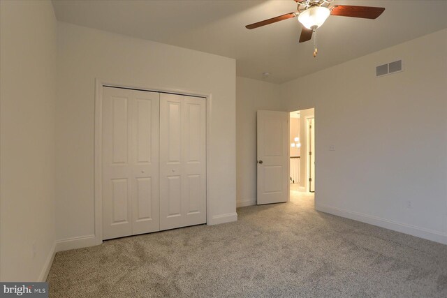 unfurnished bedroom with a closet, carpet, visible vents, and baseboards