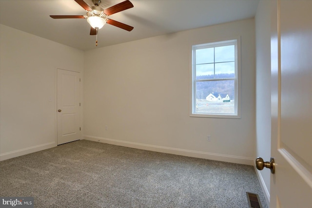 unfurnished room featuring a ceiling fan, carpet flooring, visible vents, and baseboards