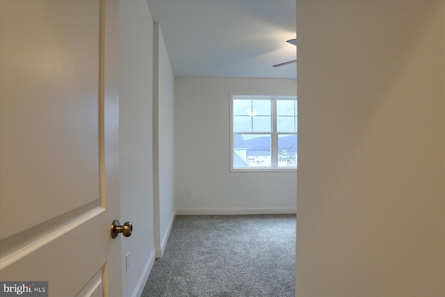 spare room featuring ceiling fan, baseboards, and carpet flooring