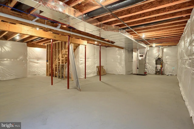 unfinished below grade area featuring gas water heater and heating unit