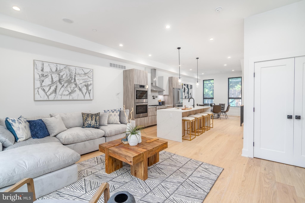 living room with sink and light hardwood / wood-style floors