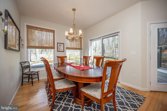 dining area with an inviting chandelier, plenty of natural light, and light wood-type flooring