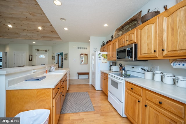 kitchen with white appliances, sink, and light hardwood / wood-style flooring