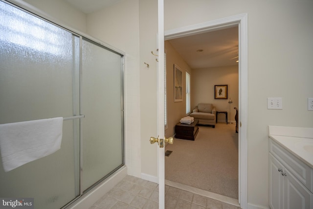 bathroom with walk in shower, tile floors, and vanity