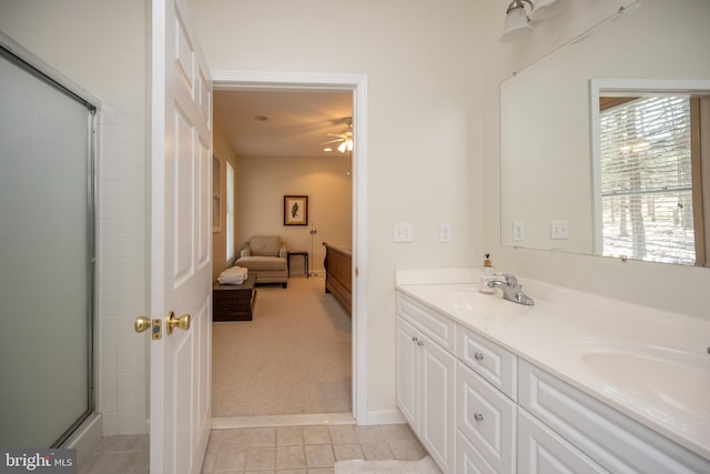 bathroom featuring double sink, ceiling fan, vanity with extensive cabinet space, a shower with shower door, and tile floors