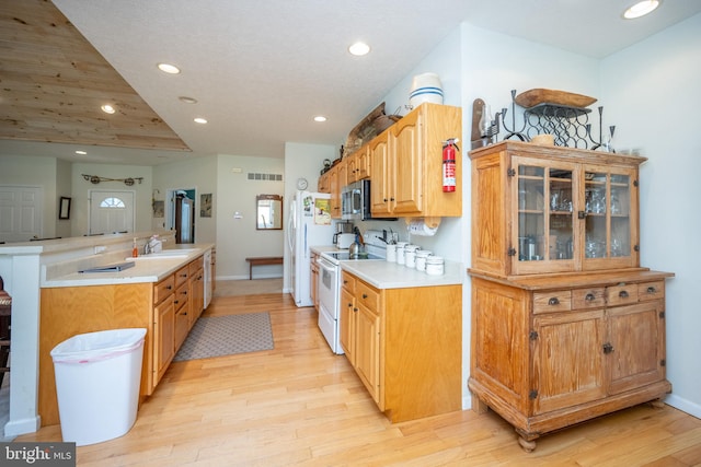 kitchen featuring white appliances, sink, and light hardwood / wood-style flooring