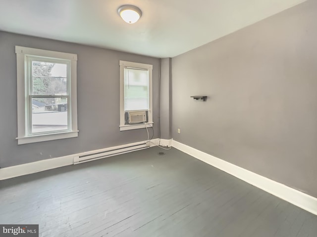 spare room featuring baseboard heating, cooling unit, and hardwood / wood-style flooring