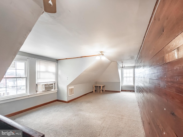 bonus room featuring cooling unit, lofted ceiling, carpet floors, and wood walls