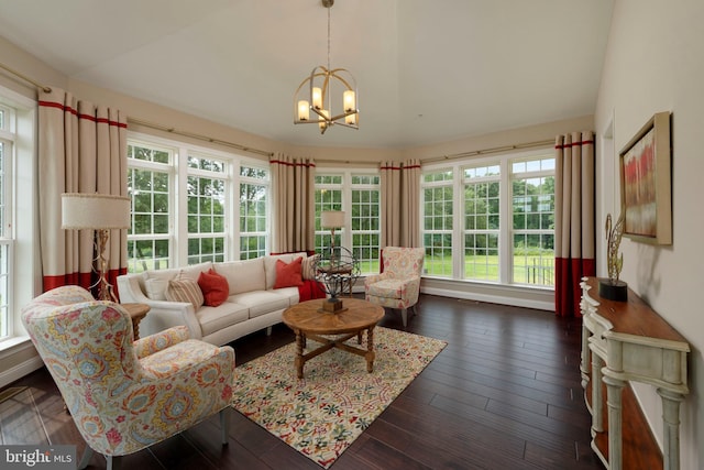 living room featuring an inviting chandelier, dark hardwood / wood-style flooring, and a wealth of natural light