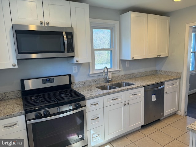 kitchen featuring stainless steel appliances, white cabinetry, and sink