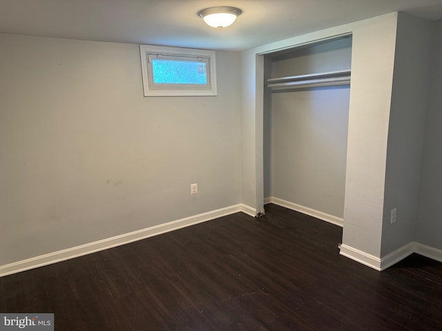 unfurnished bedroom featuring a closet and dark hardwood / wood-style flooring