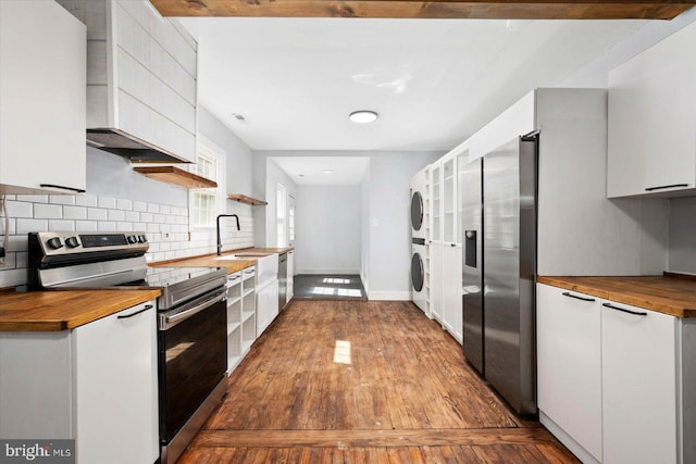 kitchen with appliances with stainless steel finishes, butcher block counters, and white cabinetry