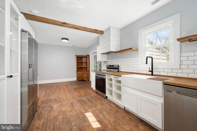 kitchen with butcher block countertops, stainless steel appliances, backsplash, dark hardwood / wood-style floors, and white cabinets