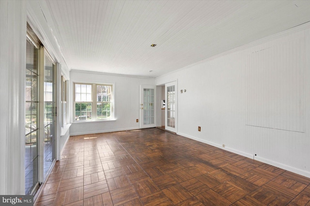 spare room with dark parquet flooring, french doors, and ornamental molding