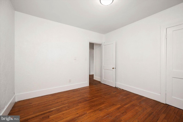 empty room with dark hardwood / wood-style floors