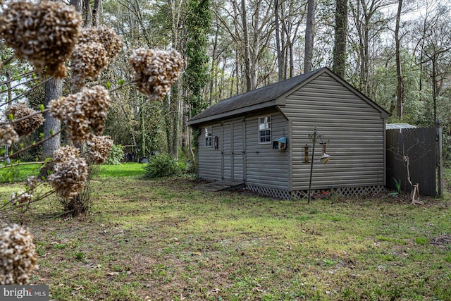 view of side of home with a yard and a storage shed