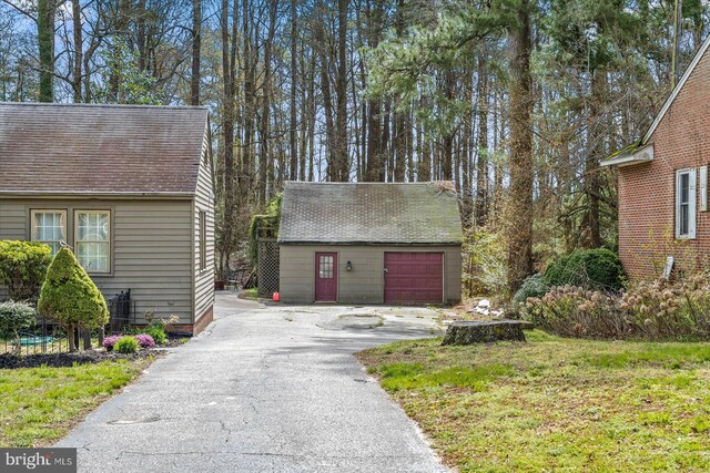 view of front facade featuring a front yard, an outdoor structure, and a garage