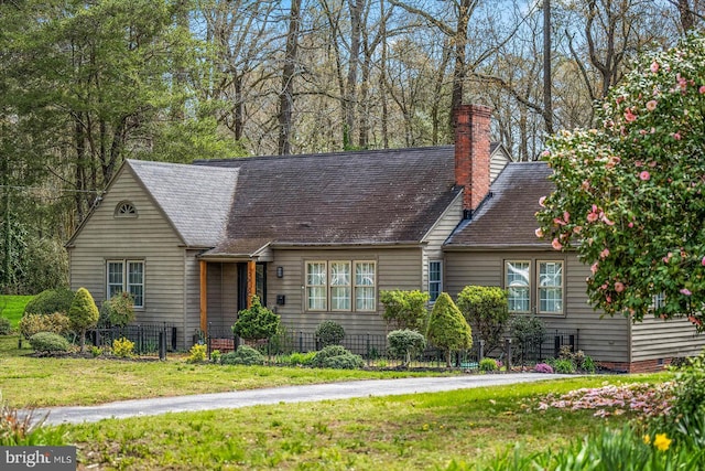 cape cod house featuring a front lawn