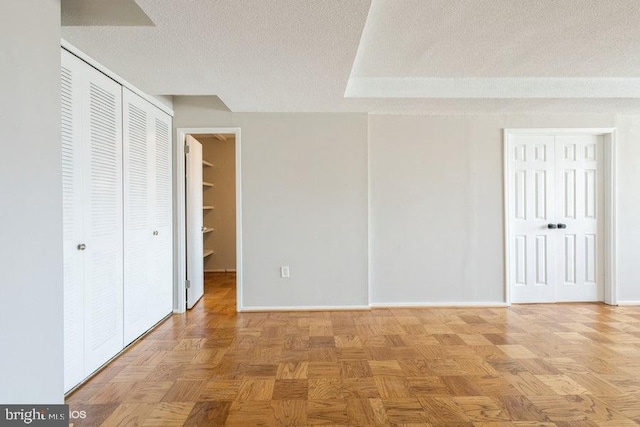 unfurnished bedroom featuring a textured ceiling and light parquet floors