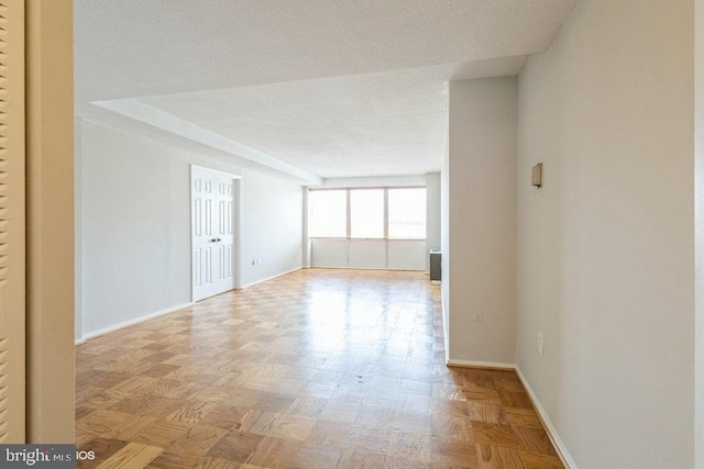 unfurnished room with light parquet floors and a textured ceiling