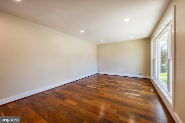 unfurnished room with dark wood-type flooring