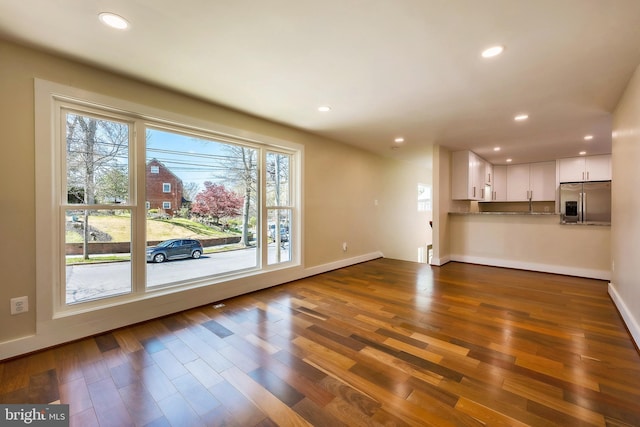 unfurnished living room featuring wood-type flooring and plenty of natural light