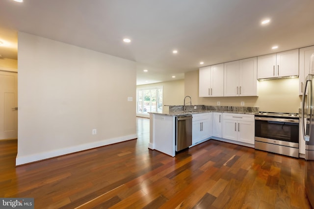 kitchen featuring kitchen peninsula, white cabinetry, appliances with stainless steel finishes, dark hardwood / wood-style floors, and light stone counters