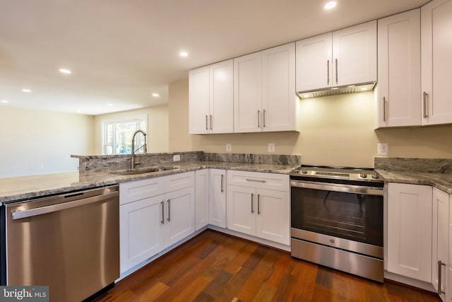 kitchen featuring light stone counters, white cabinetry, dark hardwood / wood-style flooring, stainless steel appliances, and kitchen peninsula