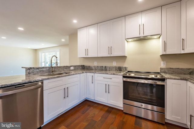 kitchen featuring appliances with stainless steel finishes, light stone counters, white cabinets, sink, and dark hardwood / wood-style flooring