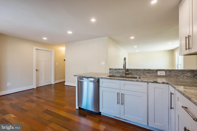 kitchen with dark hardwood / wood-style flooring, white cabinetry, dishwasher, and light stone counters