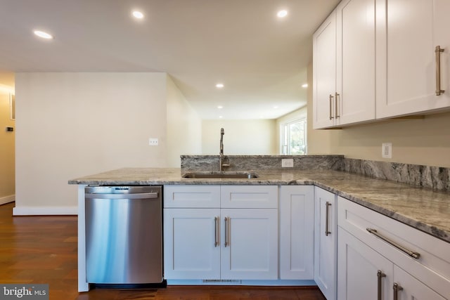 kitchen with sink, dishwasher, white cabinetry, dark hardwood / wood-style floors, and light stone countertops