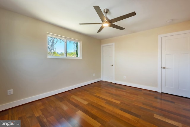 unfurnished room featuring dark wood-type flooring and ceiling fan