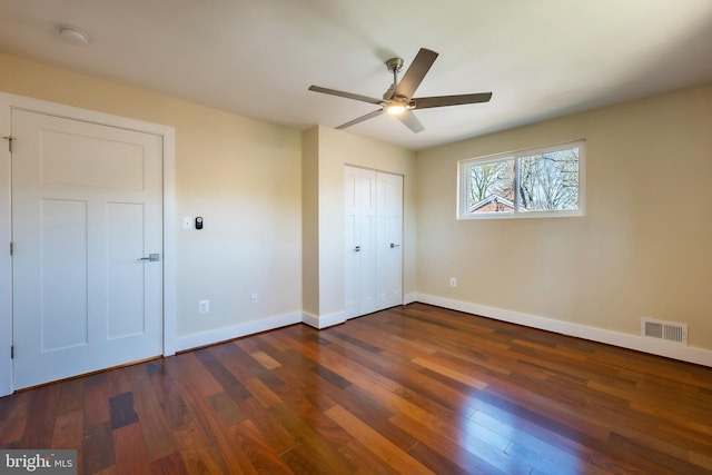 unfurnished bedroom with a closet, ceiling fan, and dark wood-type flooring