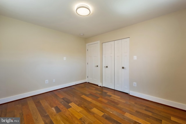 unfurnished bedroom featuring a closet and dark hardwood / wood-style floors