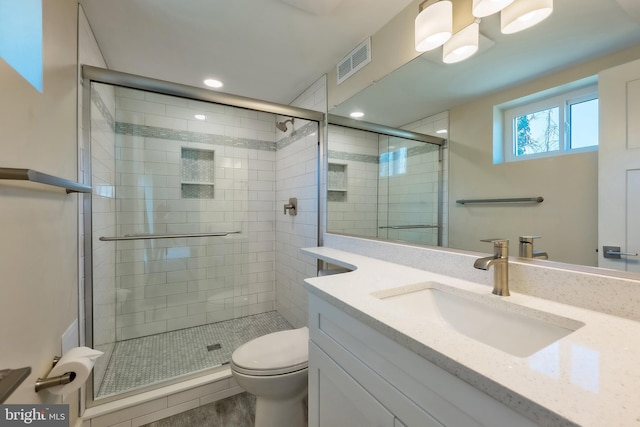 bathroom featuring walk in shower, oversized vanity, and toilet